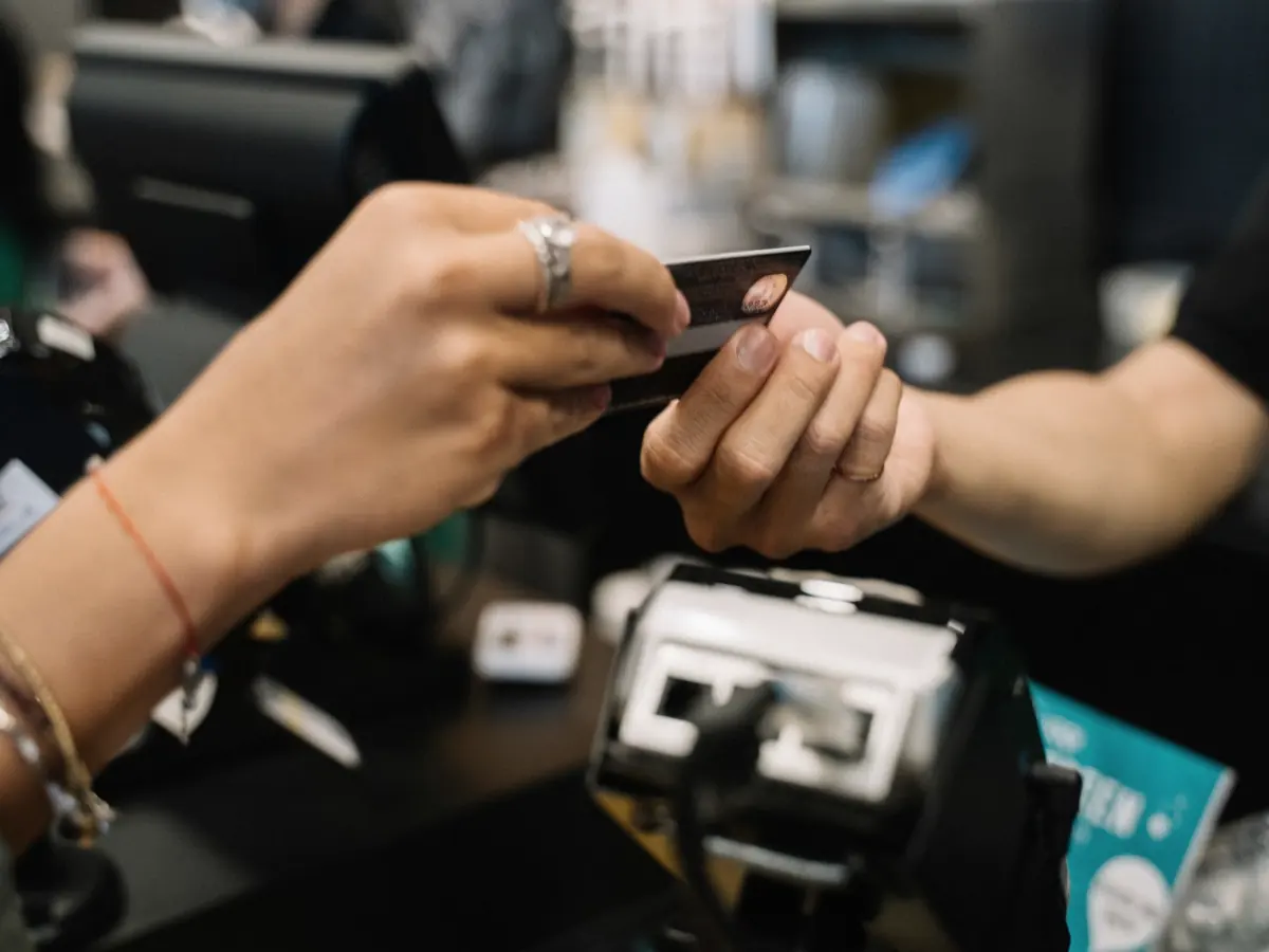 Cliente entregando o cartão para pagar no caixa